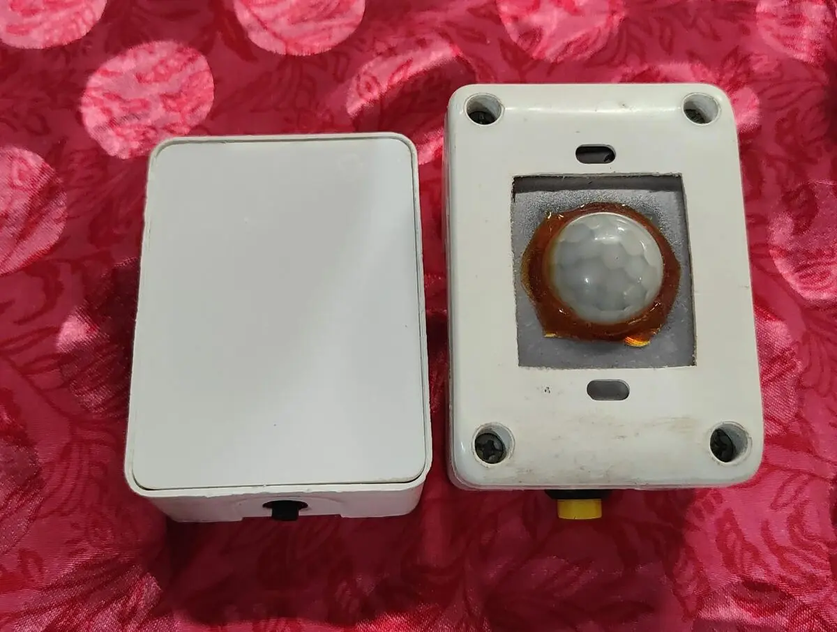 Two white wall-mount enclosures, one with a PIR motion sensor dome